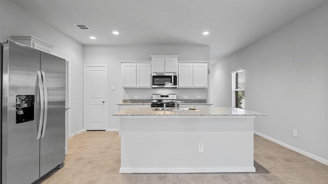 kitchen with light stone counters, a kitchen island with sink, stainless steel appliances, white cabinetry, and visible vents