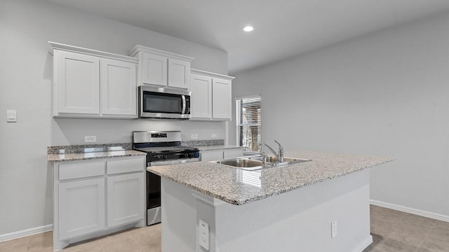 kitchen featuring white cabinets, baseboards, appliances with stainless steel finishes, and a sink