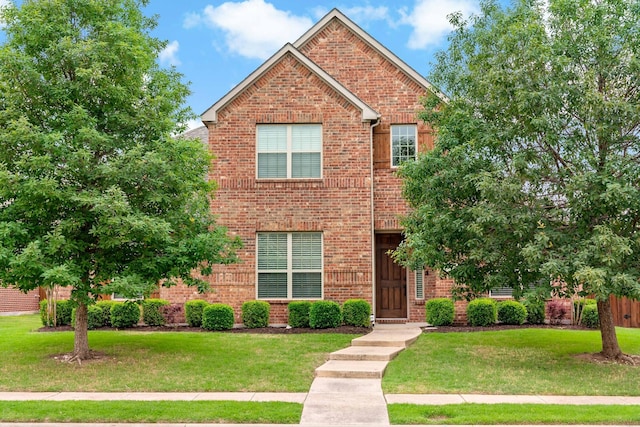 view of front facade with a front lawn and brick siding