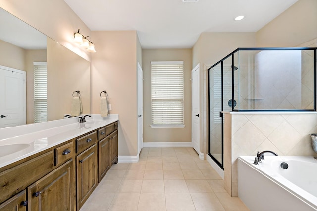full bathroom with tile patterned flooring, double vanity, baseboards, a bath, and a stall shower