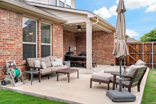 view of patio featuring fence, ceiling fan, and outdoor lounge area