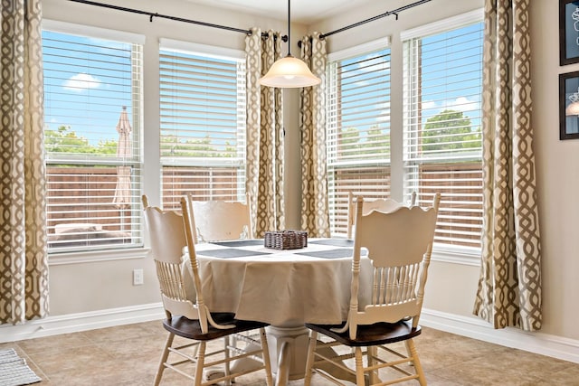 dining space with baseboards, plenty of natural light, and light tile patterned floors