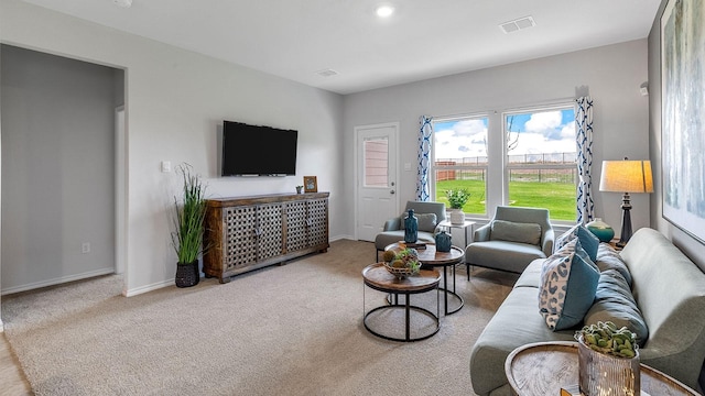 carpeted living area featuring visible vents and baseboards