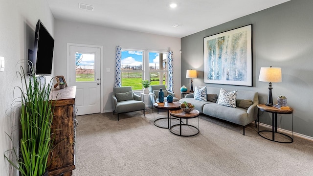 living room with carpet floors, baseboards, and visible vents