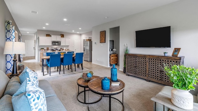 living area featuring baseboards, light carpet, recessed lighting, and visible vents