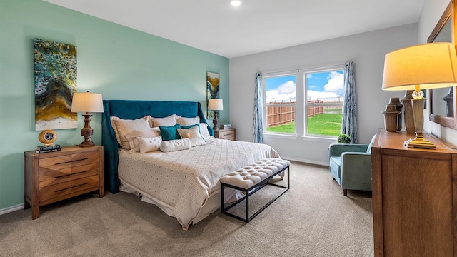 bedroom with baseboards and light carpet