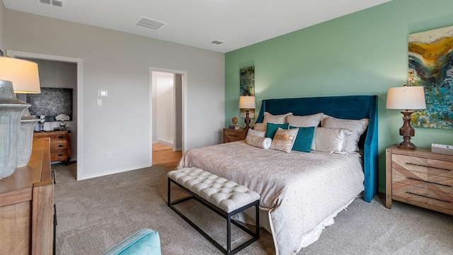 bedroom with visible vents, carpet, and a walk in closet