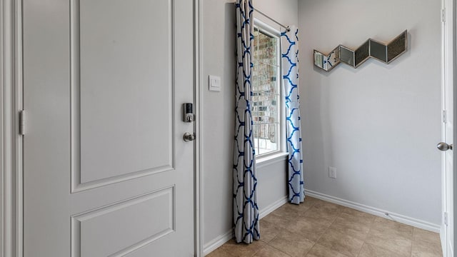 entryway featuring baseboards and light tile patterned floors