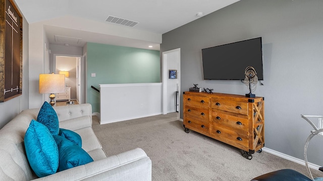 carpeted living area featuring visible vents and baseboards