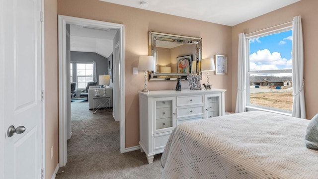 carpeted bedroom with baseboards and lofted ceiling