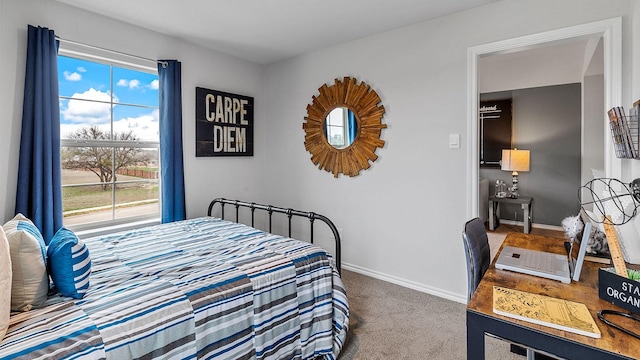carpeted bedroom featuring baseboards and multiple windows