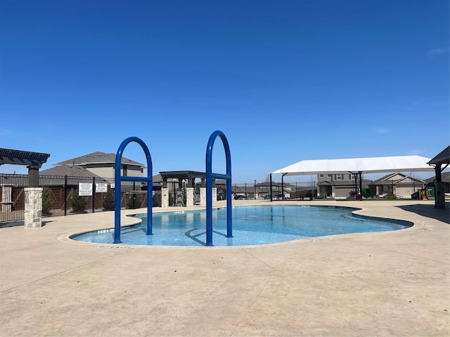community pool featuring fence and a patio