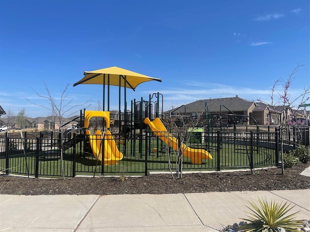 communal playground featuring fence and a residential view