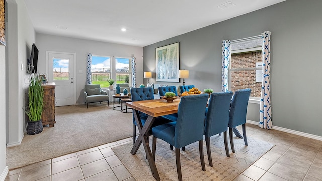 dining area featuring light colored carpet, baseboards, light tile patterned floors, and visible vents