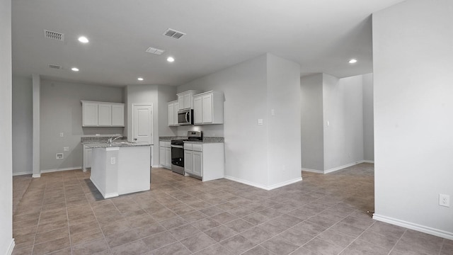 kitchen with visible vents, a kitchen island with sink, open floor plan, recessed lighting, and stainless steel appliances