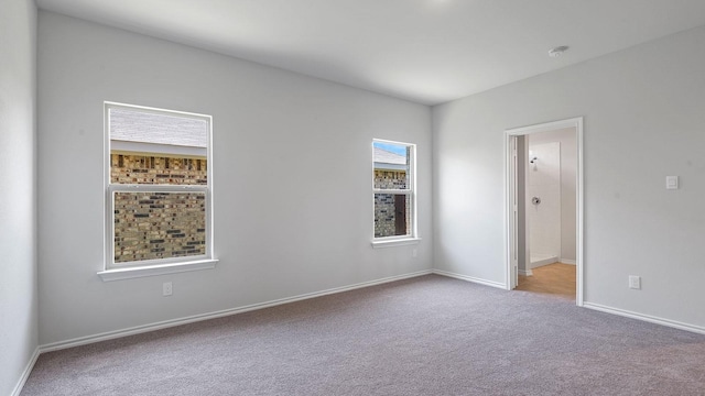 empty room featuring baseboards and carpet