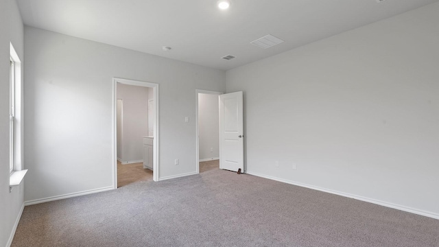 unfurnished bedroom with baseboards, carpet flooring, and visible vents