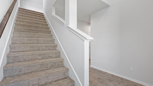stairs with baseboards and tile patterned floors