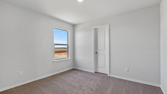 carpeted empty room with baseboards