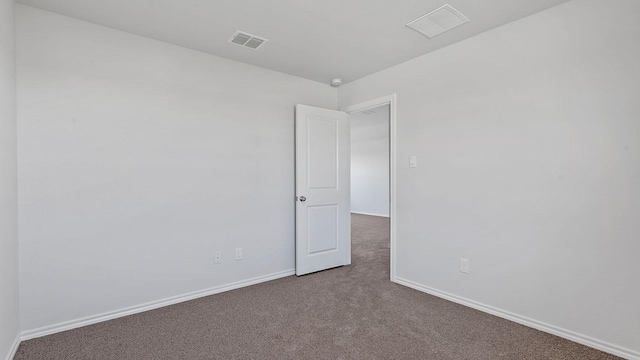 carpeted empty room with visible vents and baseboards