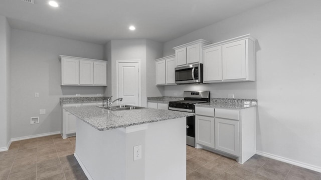 kitchen featuring an island with sink, recessed lighting, white cabinets, a sink, and appliances with stainless steel finishes