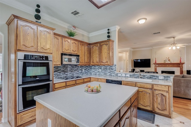 3002 Silver Springs Way, Rowlett, TX 75089 - kitchen with black appliances, open floor plan, a peninsula, a fireplace, and light countertops