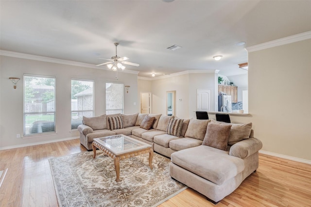 living room with visible vents, light wood-style flooring, ceiling fan, and baseboards