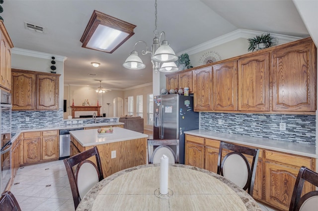 kitchen featuring light countertops, ceiling fan, appliances with stainless steel finishes, and a center island