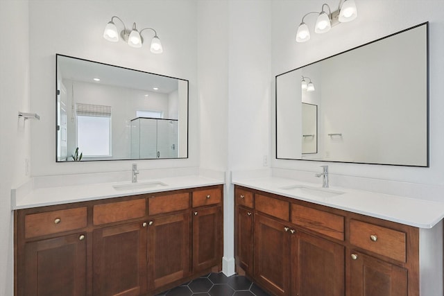 full bathroom with a sink, a shower stall, and two vanities