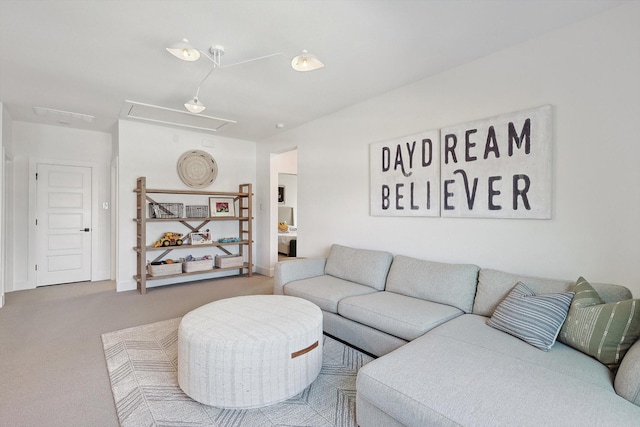 carpeted living area featuring attic access