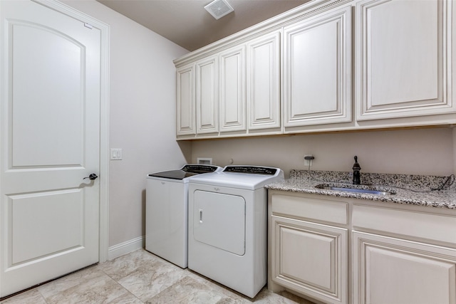 clothes washing area with cabinet space, independent washer and dryer, a sink, baseboards, and visible vents