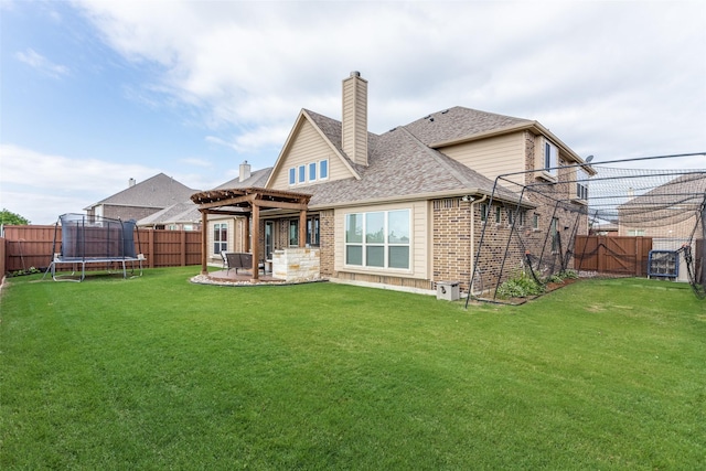 rear view of house with a chimney, a trampoline, brick siding, a fenced backyard, and a pergola