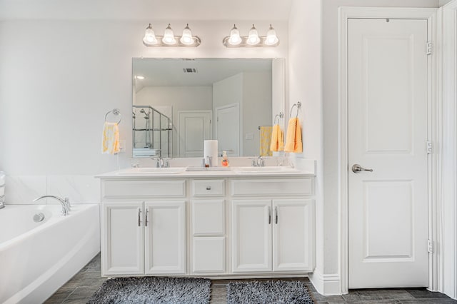 full bath with visible vents, a sink, a garden tub, and double vanity