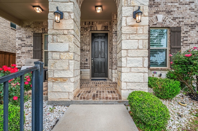 entrance to property featuring brick siding and stone siding