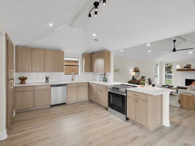 kitchen featuring light countertops, a peninsula, light brown cabinetry, and stainless steel appliances