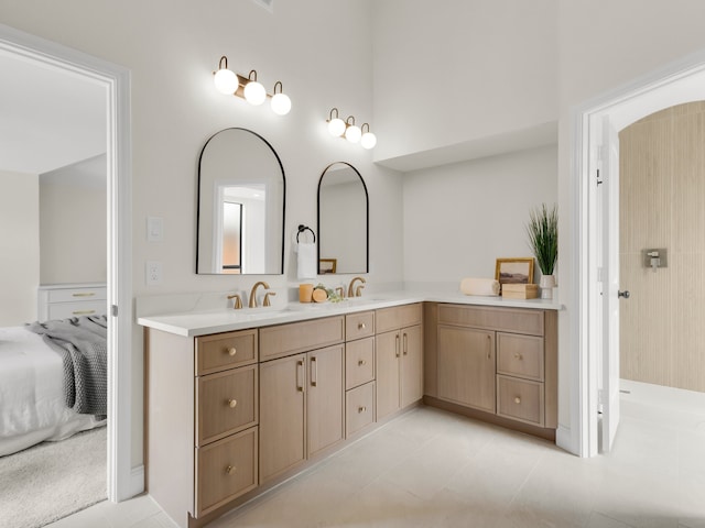 bathroom with connected bathroom, double vanity, tile patterned floors, and a sink
