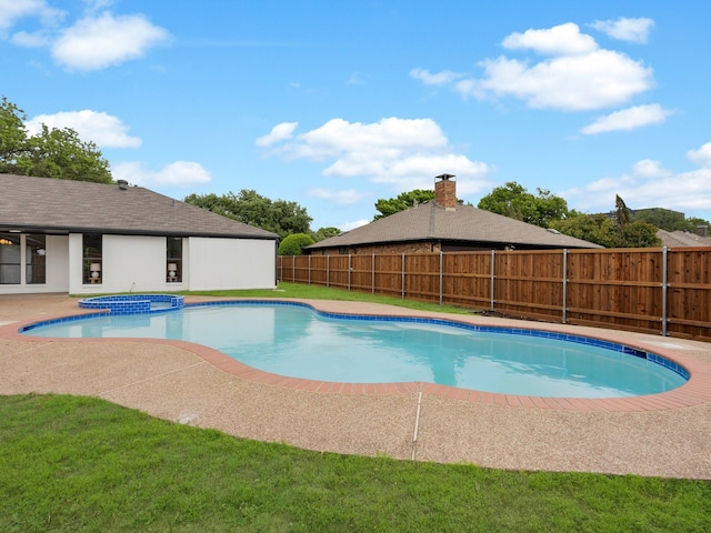 view of swimming pool featuring a patio, a pool with connected hot tub, and a fenced backyard