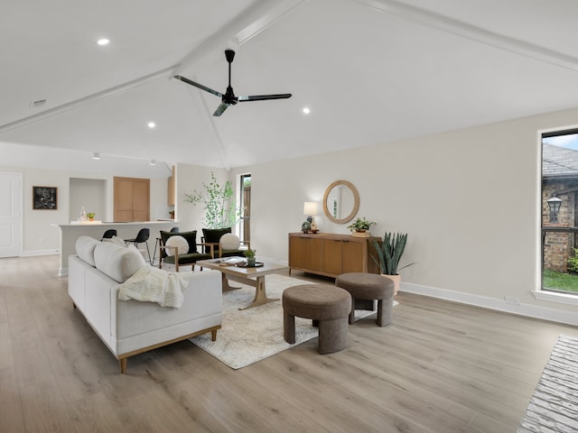 living area featuring baseboards, light wood finished floors, and beam ceiling
