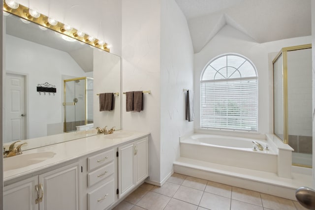 full bath with double vanity, tile patterned floors, a shower stall, a sink, and vaulted ceiling