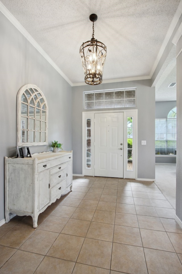 entrance foyer with baseboards, light tile patterned flooring, a textured ceiling, and a notable chandelier