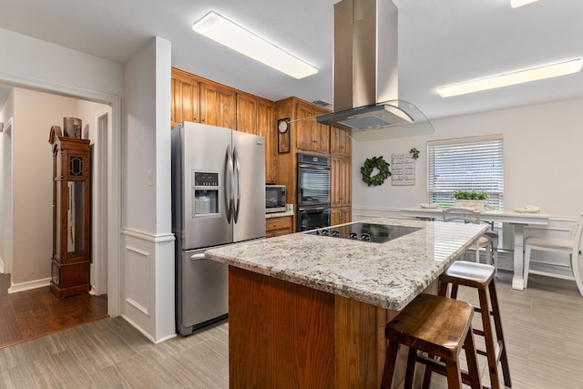 4705 El Salvador Ct, Arlington, TX 76017 - kitchen featuring a kitchen island, a kitchen bar, island exhaust hood, brown cabinets, and black appliances