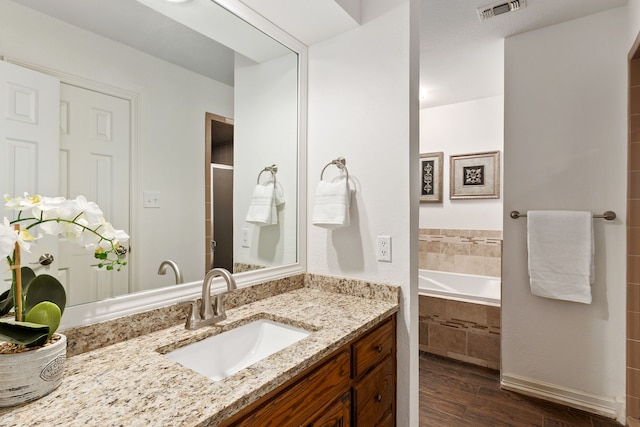 4705 El Salvador Ct, Arlington, TX 76017 - bathroom featuring visible vents, vanity, a shower with door, wood finished floors, and tiled bath