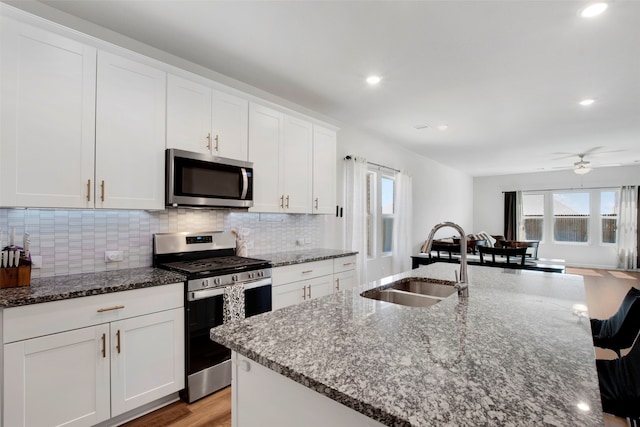 kitchen featuring appliances with stainless steel finishes, tasteful backsplash, a sink, recessed lighting, and white cabinetry