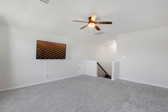 carpeted empty room with ceiling fan, lofted ceiling, and visible vents