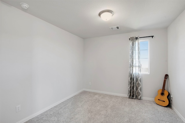 carpeted empty room with visible vents and baseboards