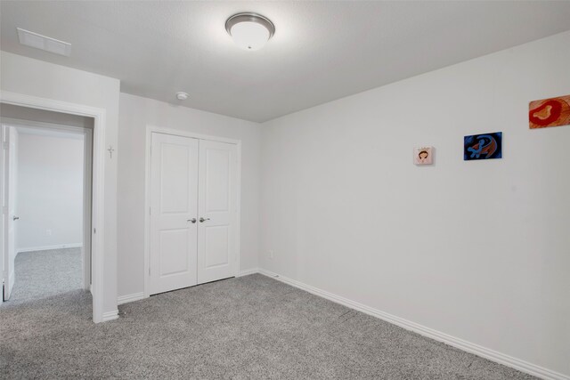 unfurnished bedroom with carpet floors, baseboards, a closet, and visible vents