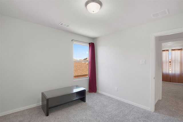 empty room featuring baseboards, visible vents, and carpet