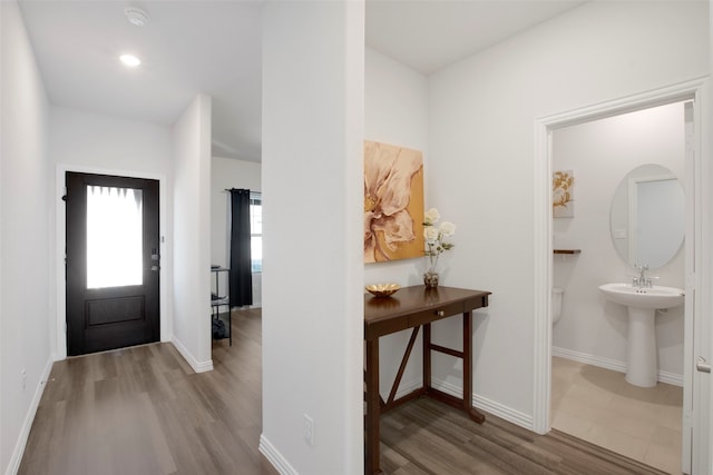 entryway featuring baseboards and wood finished floors