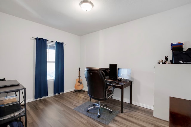 home office with baseboards and wood finished floors