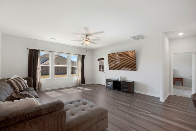 living room featuring baseboards, ceiling fan, visible vents, and wood finished floors